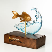 Load image into Gallery viewer, Trophy with a gold fish and water design on a wooden base, featuring 'Champion Roomy Cup 2025'.
