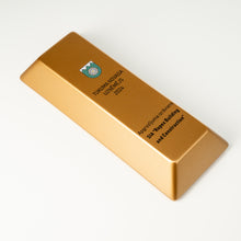 Load image into Gallery viewer, Gold bar with engraved text and logo on a white background